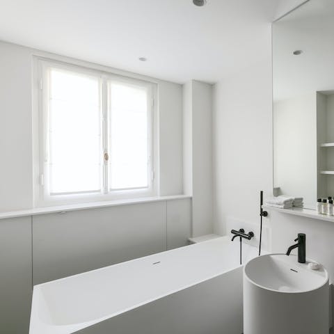 Unwind after sightseeing with a soak in the sleek bathtub